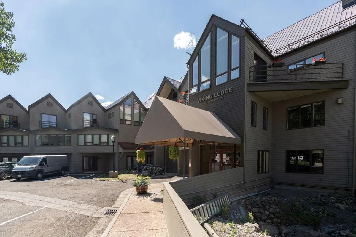 The welcoming entrance to Viking Lodge, marked by a prominent sign and awning, with several bicycles parked nearby and people enjoying the outdoor space. The inviting setting hints at both accessibility and relaxation after exploring downtown.